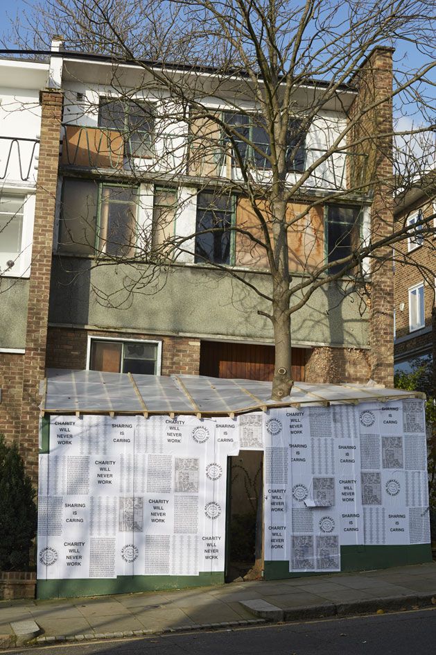 Residential building with a wooden, sheltered entrance covered in posters