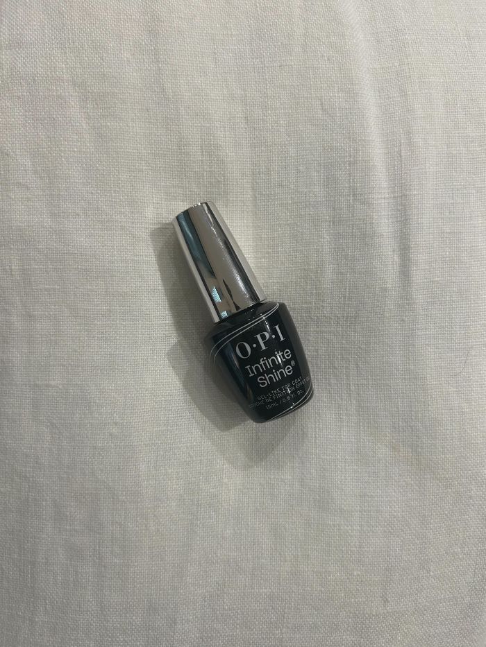 The OPI Infinite Shine Top Coat on a white linen background