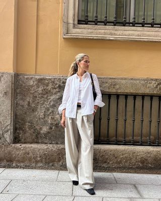 @elizagracehuber wearing white button-down, white tank, and beige trousers