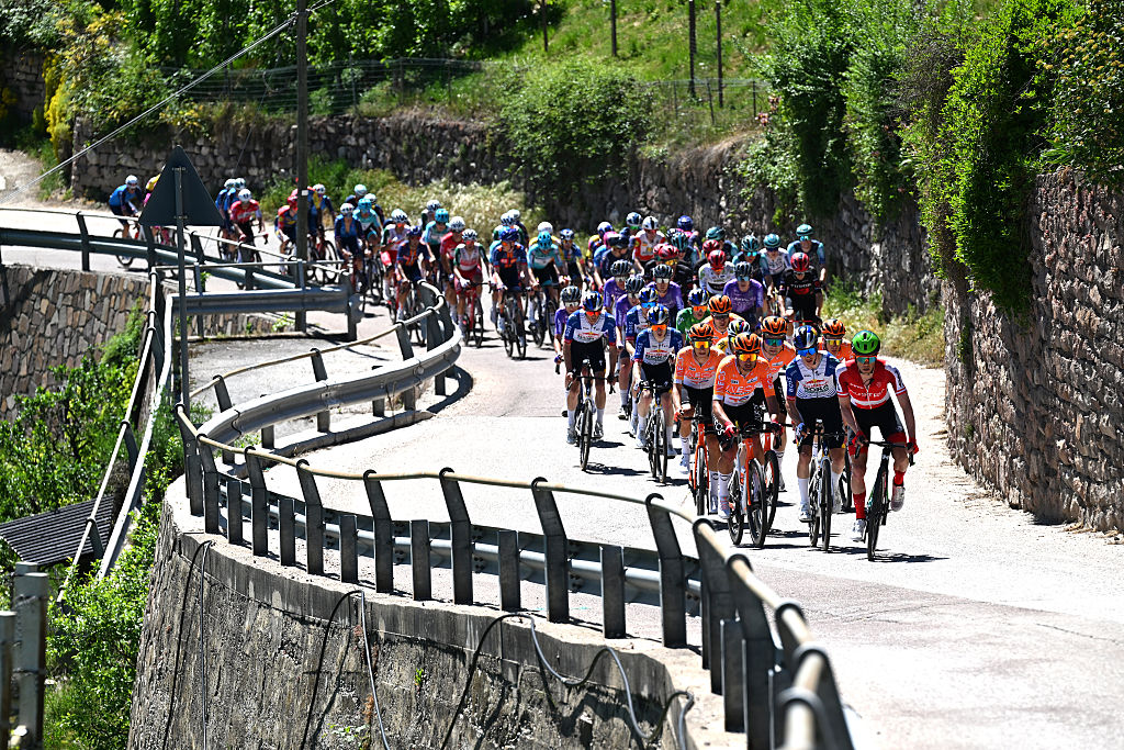 Head-on shot of the peloton snaking through a windy bit of road during a stage of the 2026 Tour of the Alps