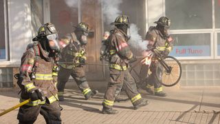 Firefighters walking with equipment in Chicago Fire season 12