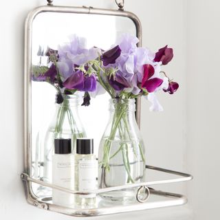 mirror on wall with flower vase