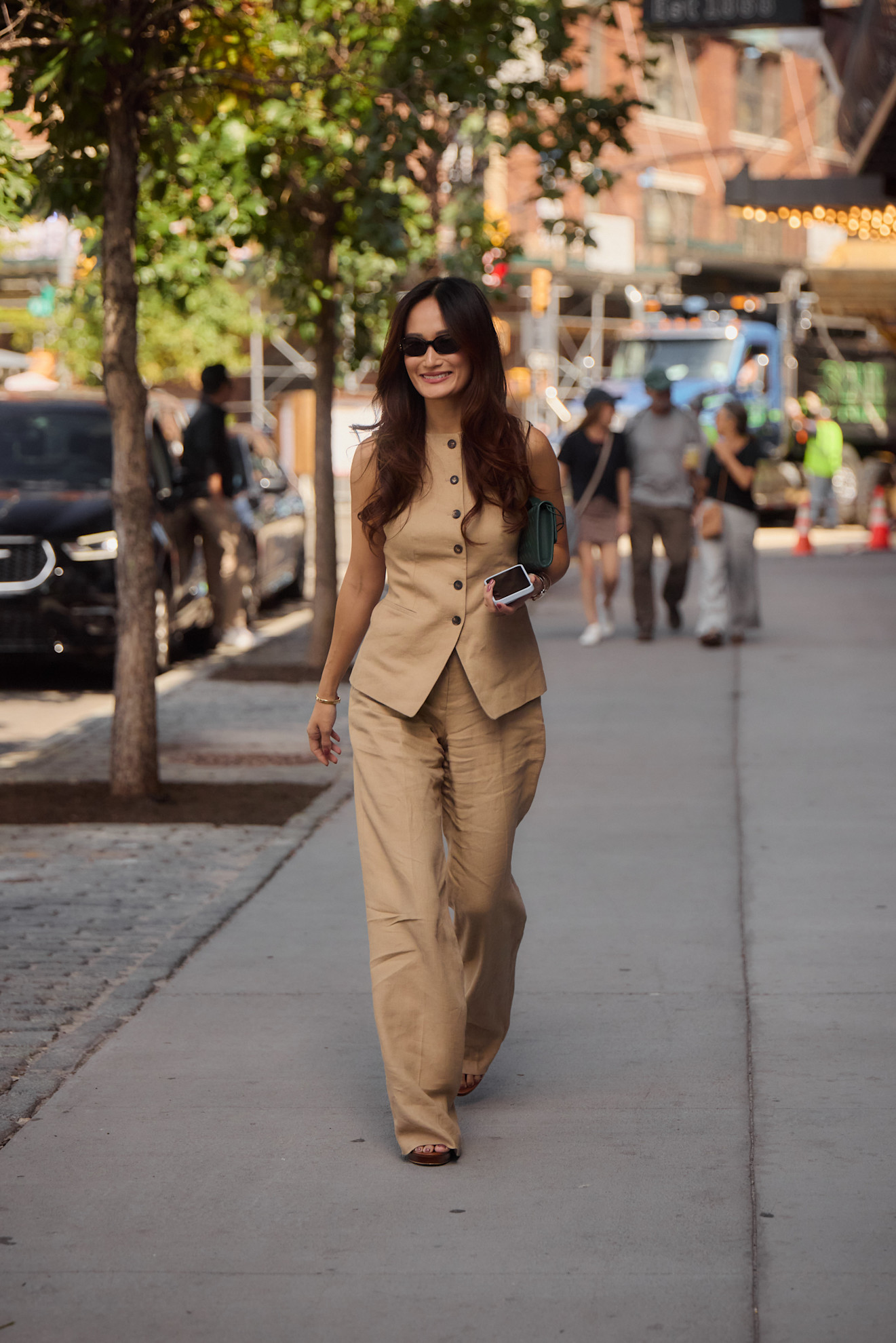 a fashion week attendee wearing sunglasses and tan matching set