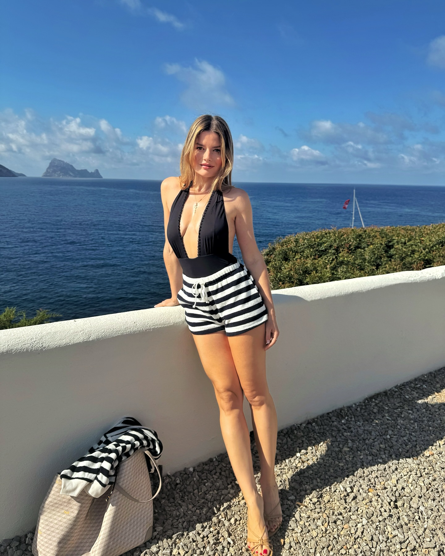spray tan tips - Sabina wearing black swimsuit and shorts in sun