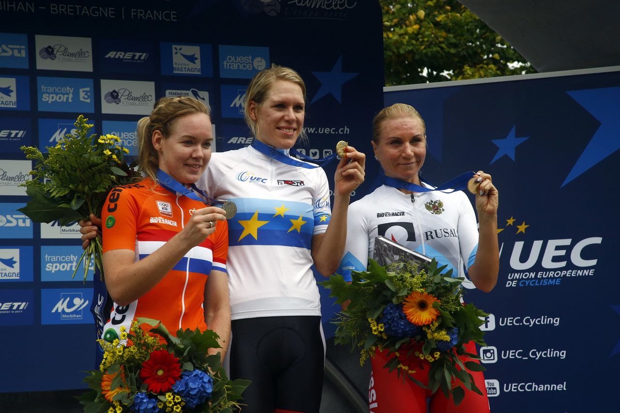 Ellen van Dijk shows off her gold medal atop the podium