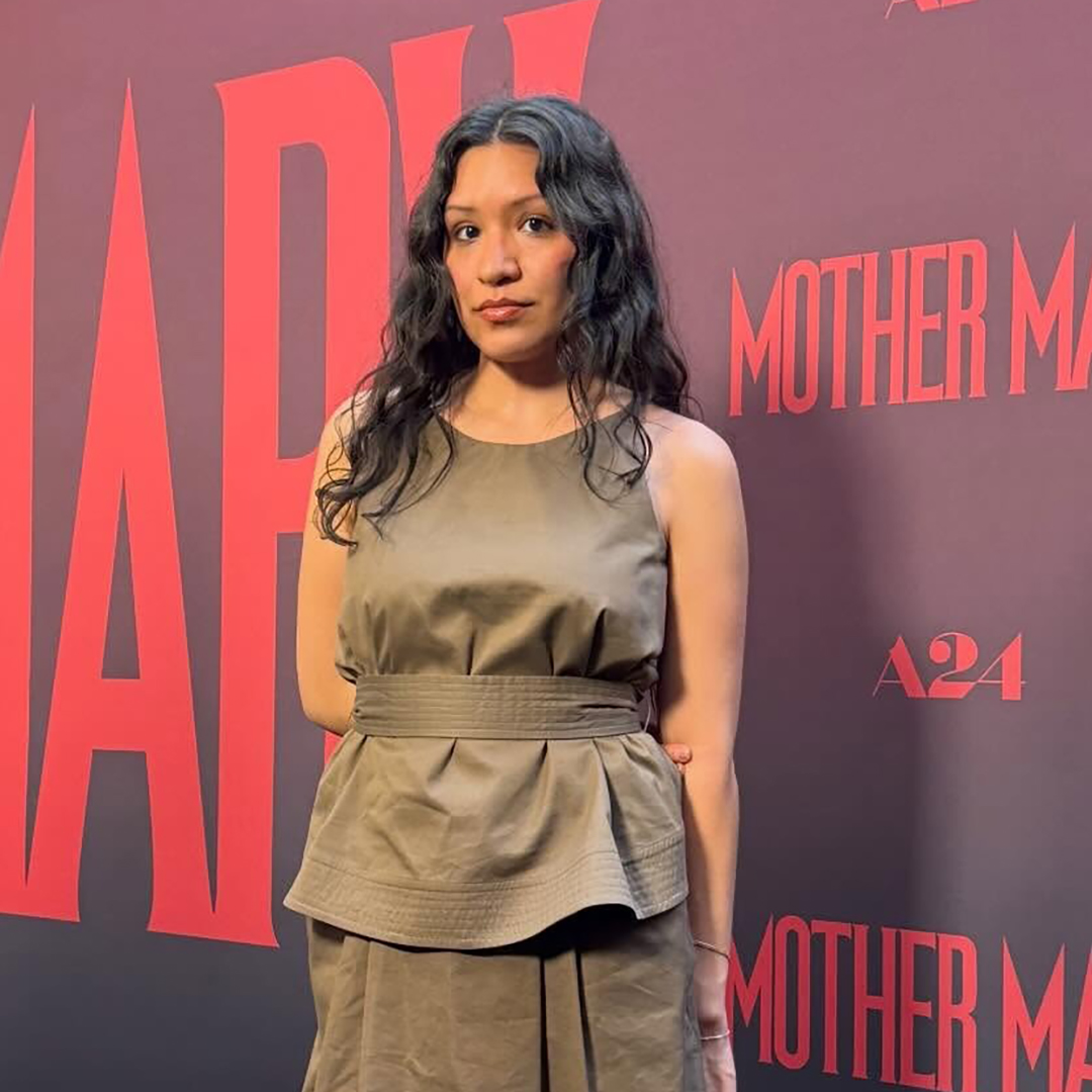 A woman wearing a tan peplum top and skirt