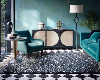 A living room next to garden with teal velvet sofa furniture by Carpetright and Diamond motif rug