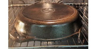 cast iron skillet upside down in an oven to show essential last step for the proper process for how to season a cast iron skillet