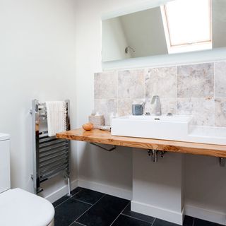 en suite bathroom with grey tiled flooring and white washbasin