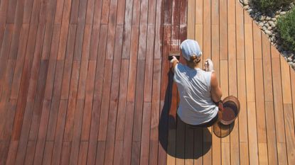woman staining a deck