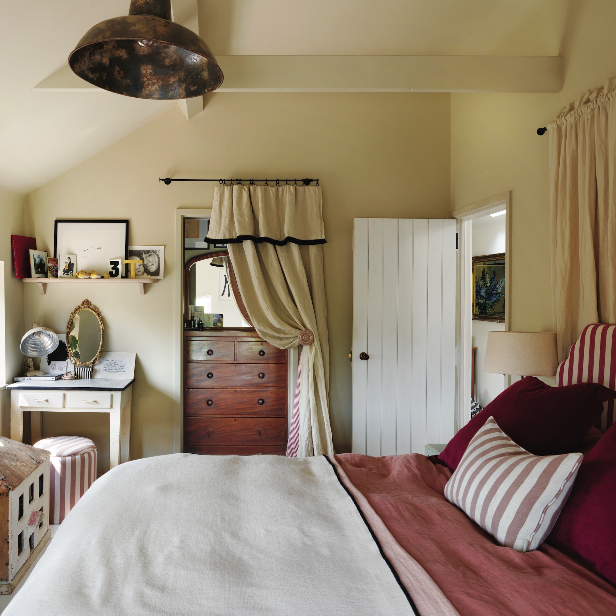 bedroom with cream painted walls and alcove for dressing area partly concealed by curtain