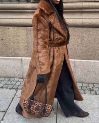 @nnennaechem wearing leopard print flats with matching bag and long faux fur coat