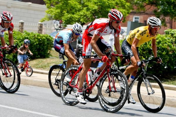 Riders accelerate while a youngster tries keeping up n the background.