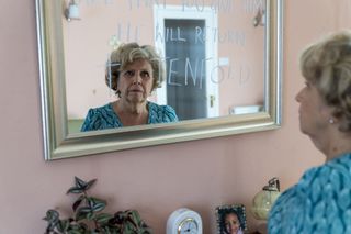 Anne Reid in The Sixth Commandment looking at a mirror with writing on