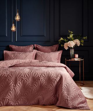 Navy paneled wall decor with pink scallop motif bedding by The French Bedroom Co