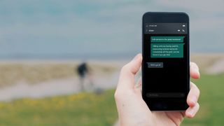 Hand holding phone in a remote beach location