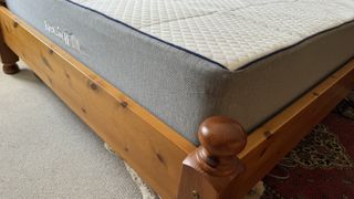 Corner shot of the Nectar Hybrid Mattress on our tester's wooden bedframe