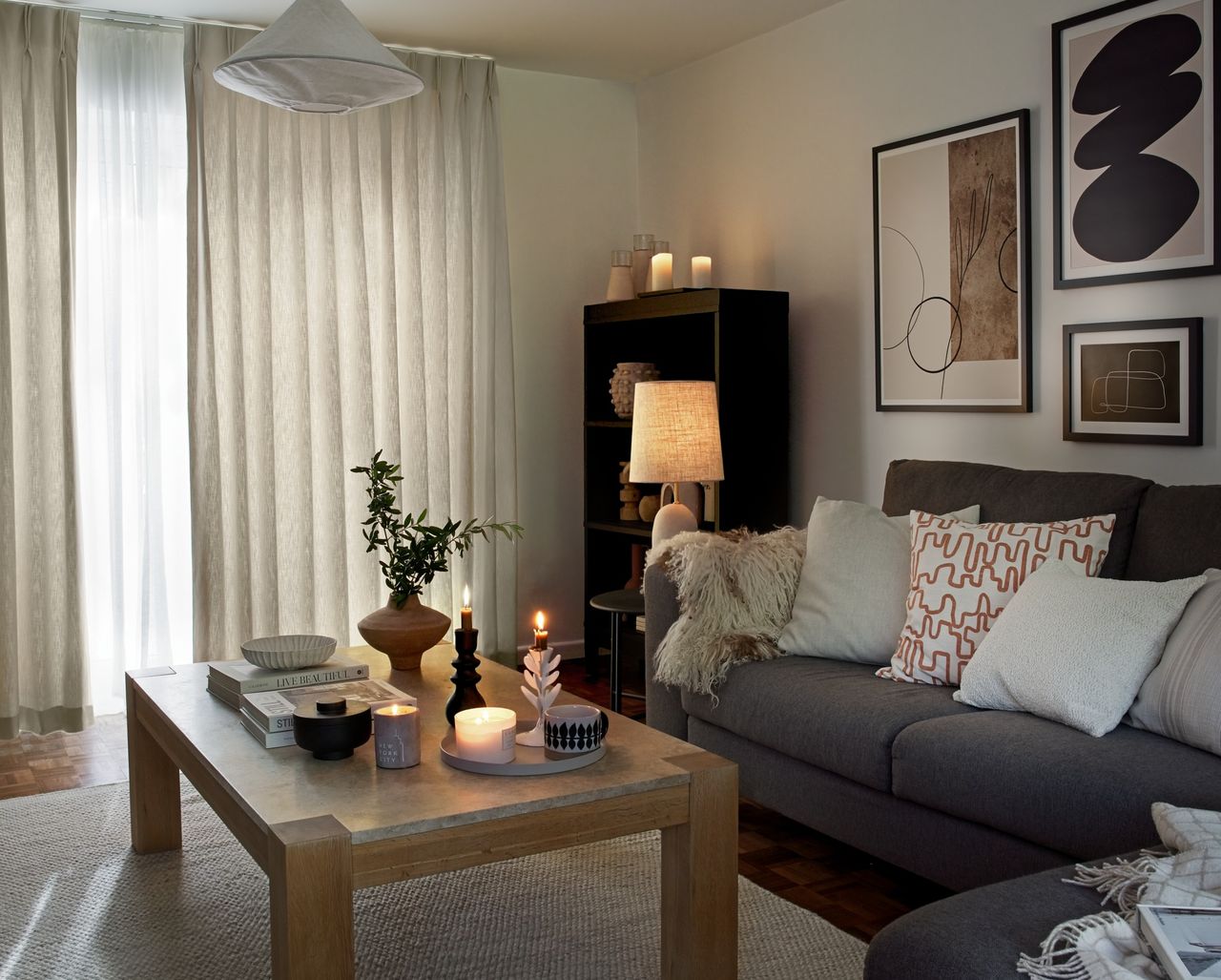 A cosy living room with French windows and pale curtains drawn