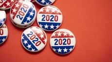 Stars-and-stripes-adorned 2020 election buttons against a bright red background
