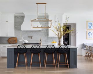 Dark color contrast kitchen island with black and wood bar stools and large lantern pendant light
