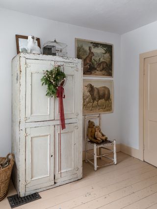 A farmhouse bedroom with a wreath on a wardrobe