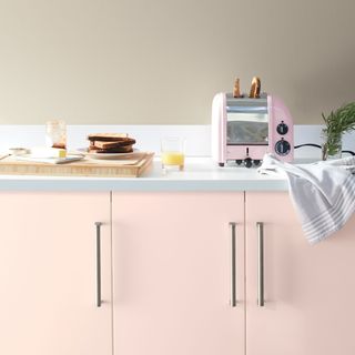 Kitchen with pink cabinetry and chrome hardware