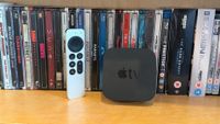 Apple TV 4K on a shelf with Blu-ray cases behind