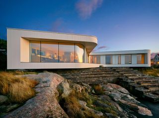 The house seems to perch on the rocks, with steps leading down to a freshwater swimming pool.