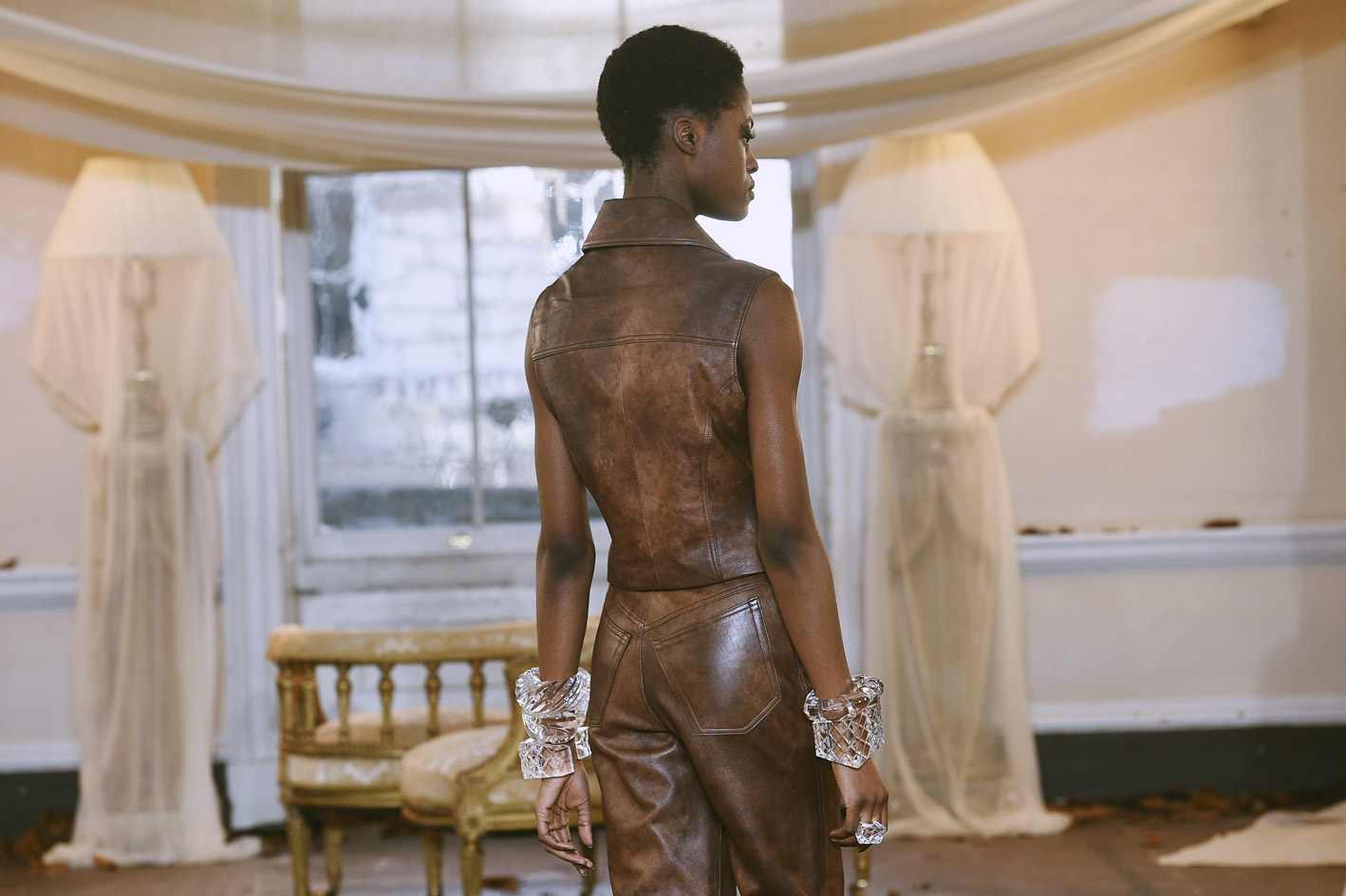 Model wears leather vest, matching trousers