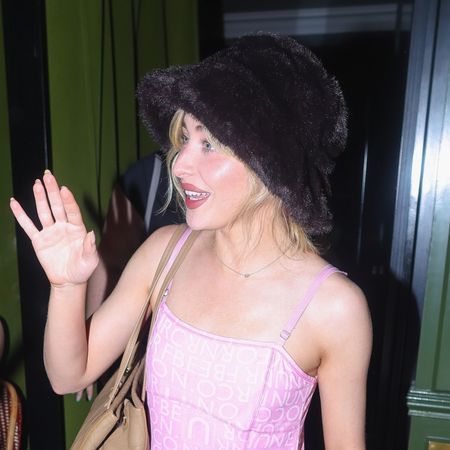 Sabrina Carpenter braves the Paris heatwave in a fluffy bucket hat, a slinky pink dress, and carrying a vintage Hermes bag