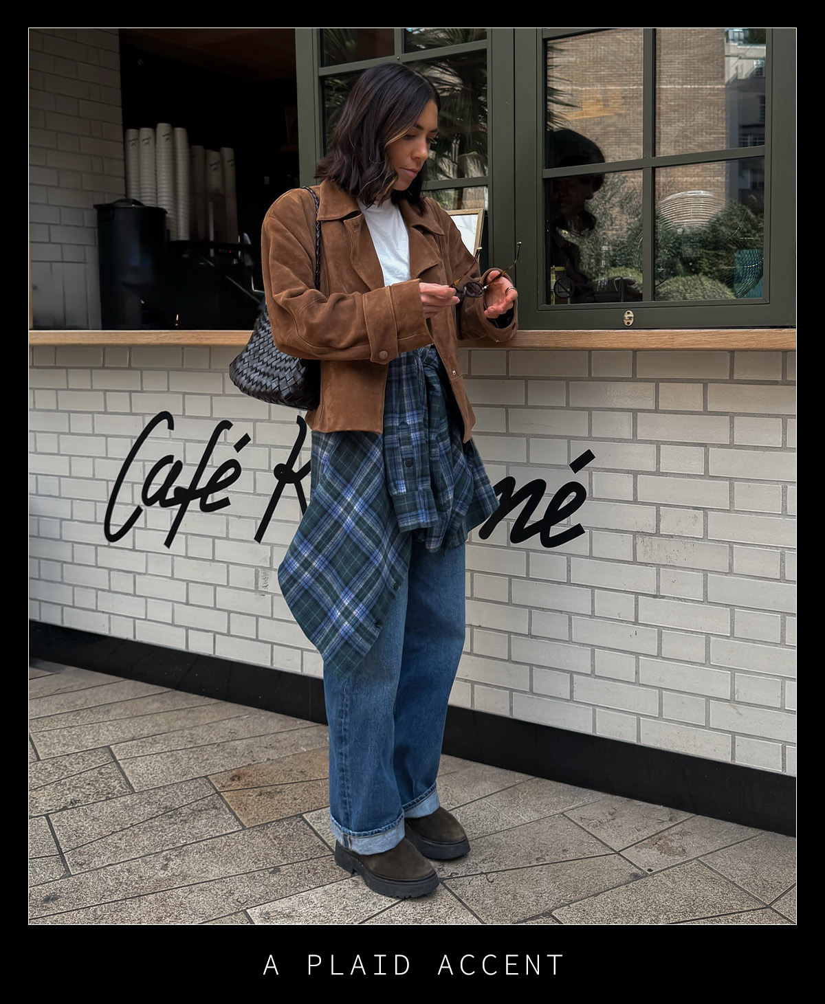 Woman in jeans, a plaid shirt, and a tan suede jacket.