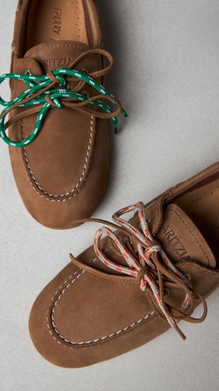 a pair of Aritzia boat shoes by Sperry in front of a plain backdrop