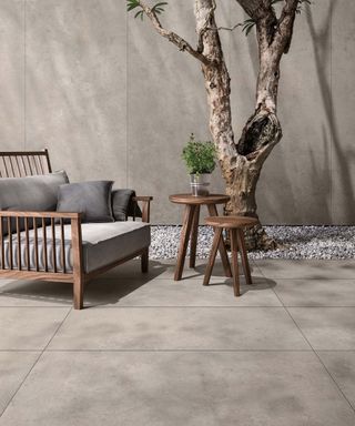 Large stone tile paving slabs in a minimalist courtyard with statement tree