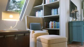 An interior of a bedroom, including corner shelves and seating