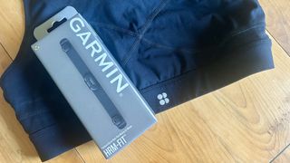 Garmin HRM Fit product box on top of a sports bra
