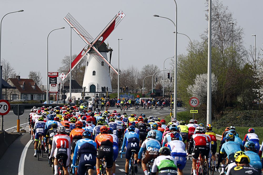 The Gent-Wevelgem peloton passes a windmill