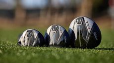3 Titleist TSi1 clubs laying on a golf course.