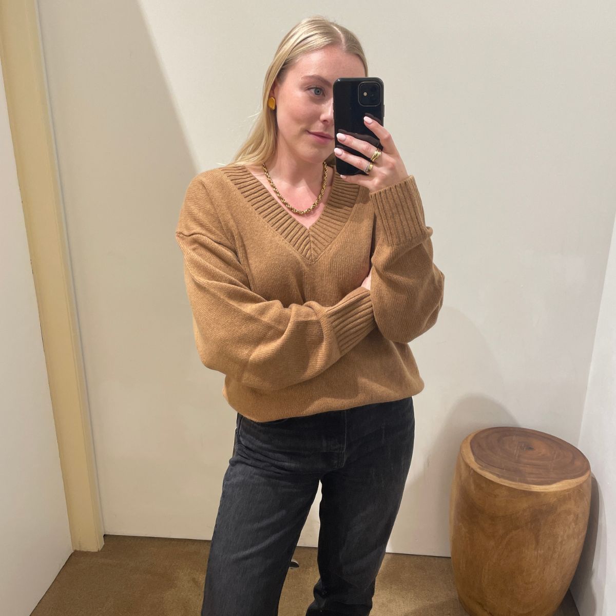 Woman wears beige v-neck jumper