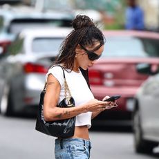 Zoe Kravitz in NYC wearing a cropped white T-shirt, low-rise crop flare jeans, and black block-heel pumps