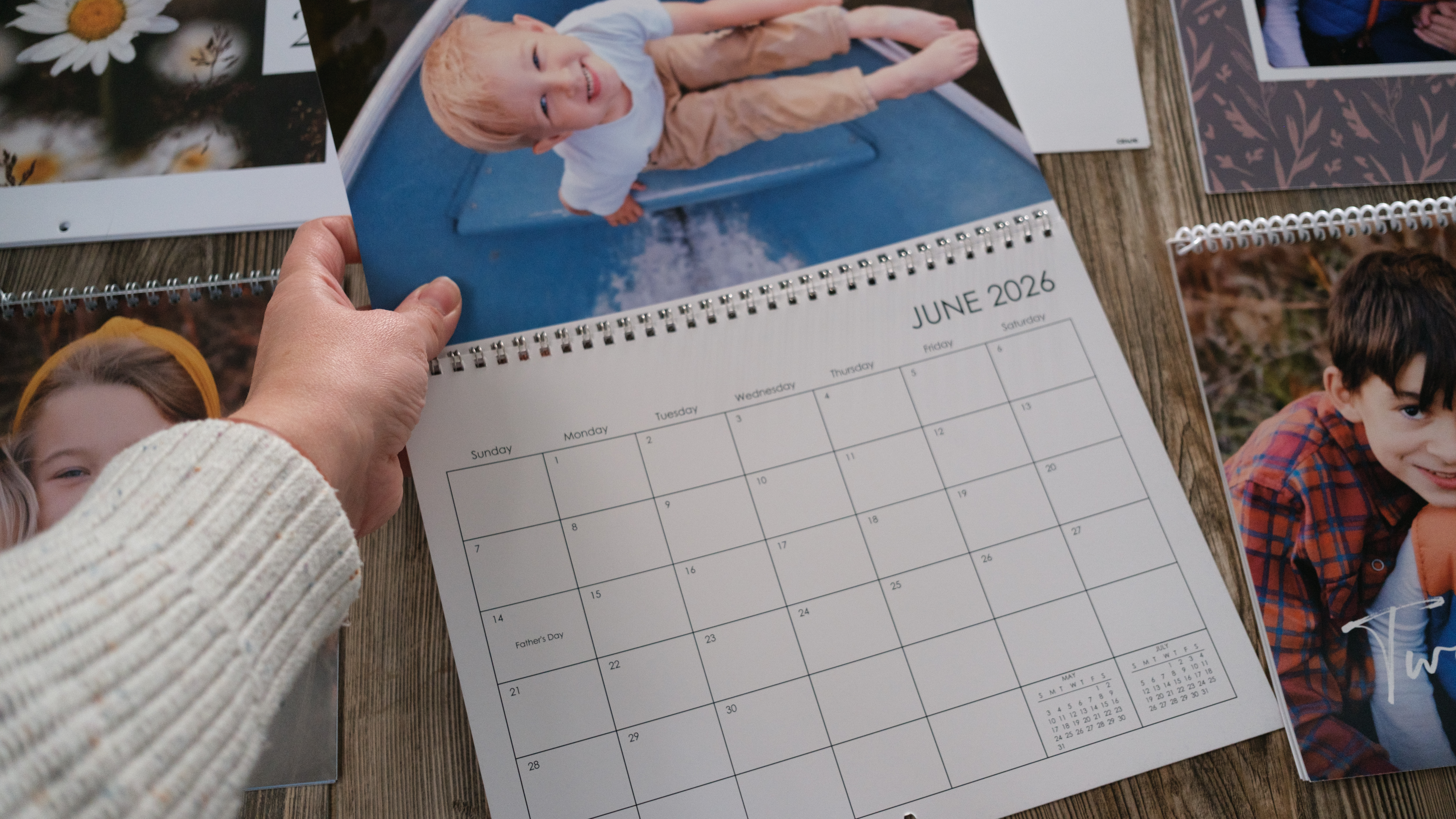 A collection of several custom photo calendars on a wood background