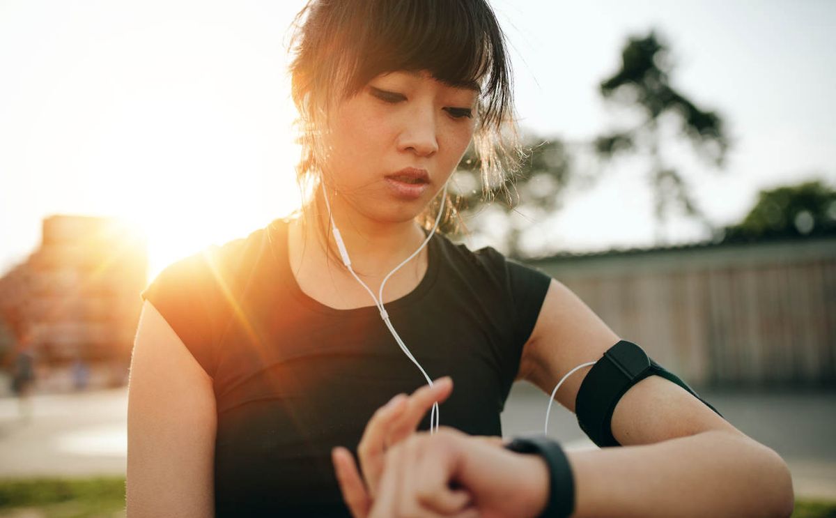 Woman looks at wearable device while running