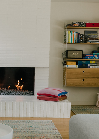 A living room with a fireplace and wall-mounted drawers