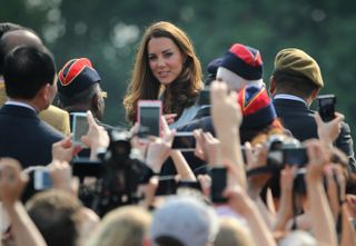 Kate Middleton surrounded by paparazzi.
