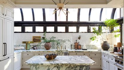 A well-lit kitchen with marble detailing and large skylights