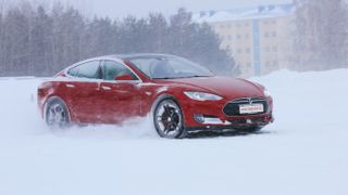 Red Teslamodel s driving in snowy conditions