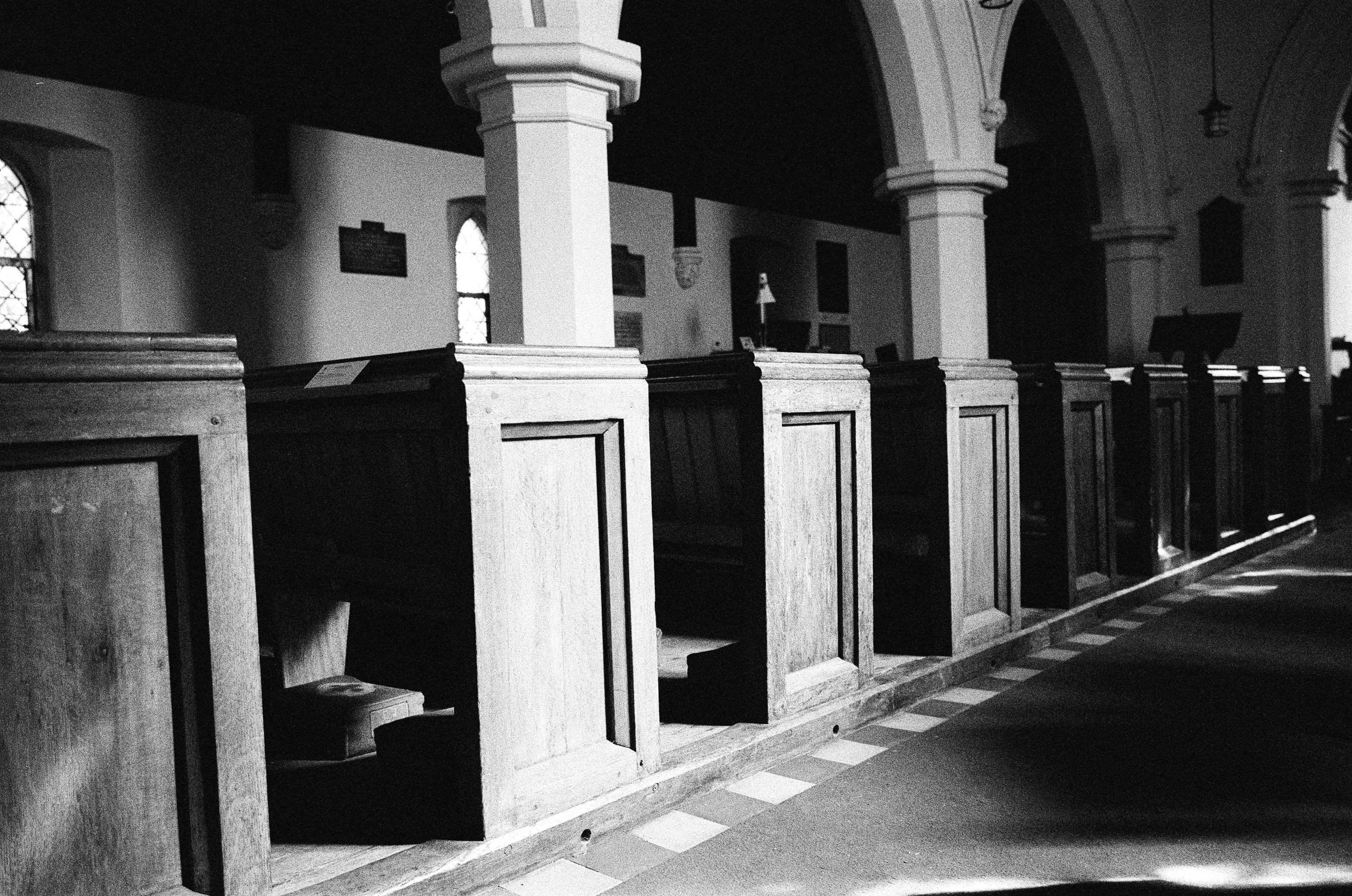 Leica MP black and white film scan of pews in a church bathed in light