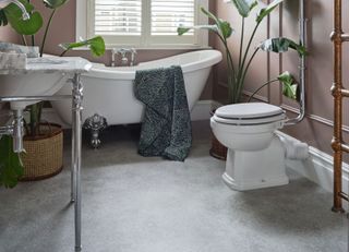 a bathroom with a concrete effect flooring