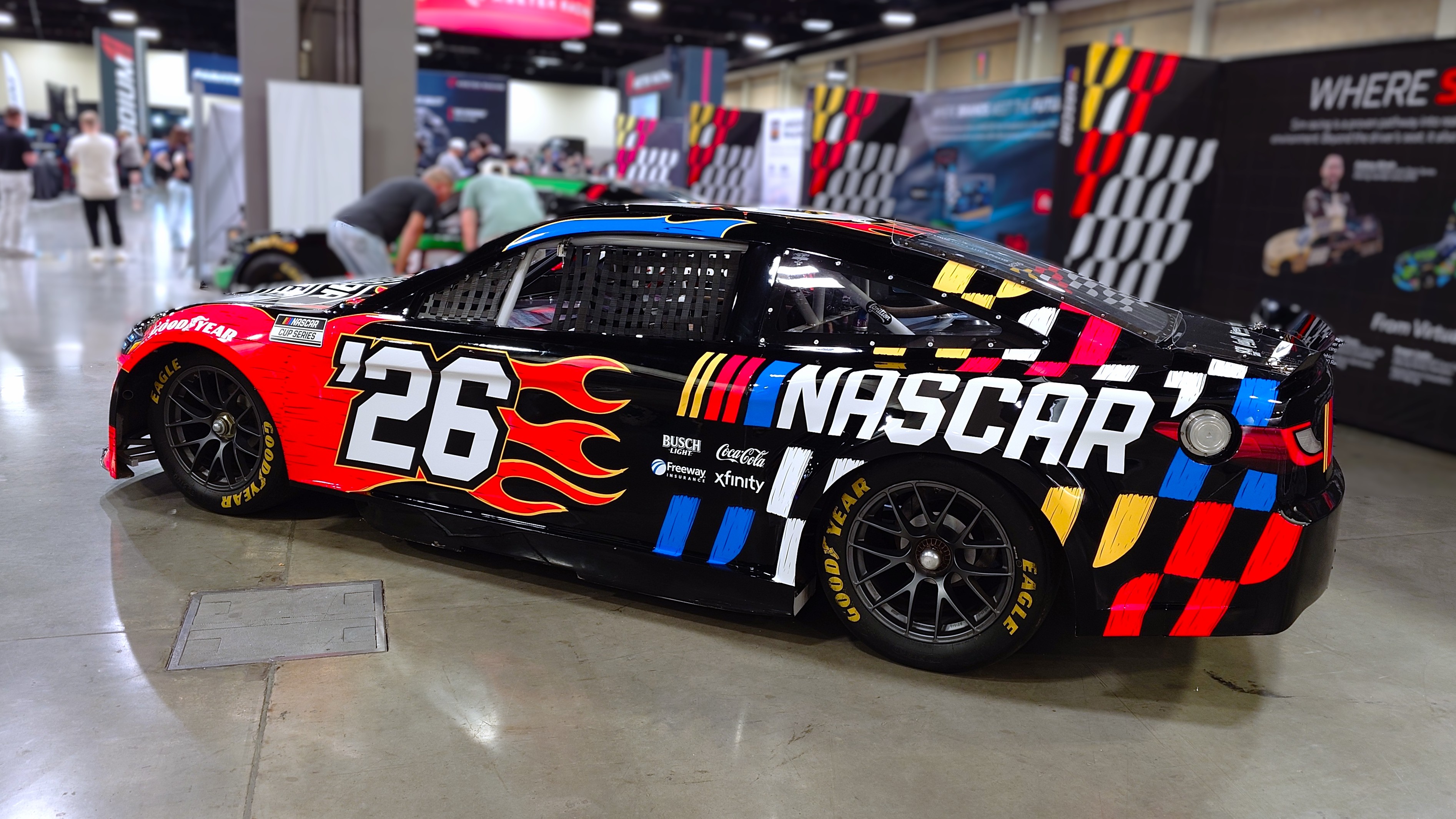 A photo of a NASCAR Cup Series car wearing a NASCAR '26 livery taken at the Charlotte Convention Center during the Sim Racing Expo.
