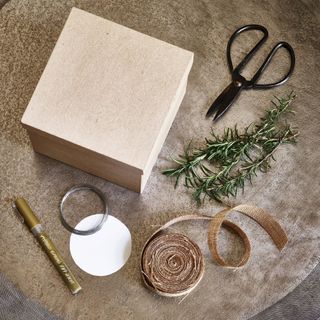 Brown box, scissors, hessian, rosemary and cards for gift wrapping