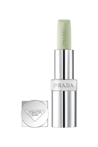 A silver tube of Prada lip balm with the cap off against a white background.